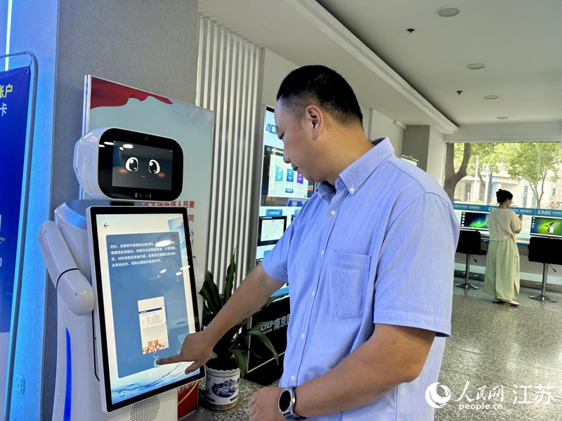 工作人员正在测试智慧医保服务机器人。人民网 王丹丹摄